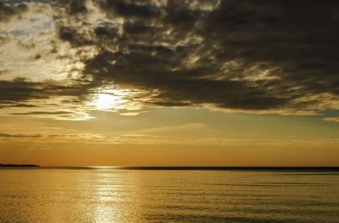 Sunset over the sea. Reflection of sunlight in the sea waves. The sky in the  Stock Photos