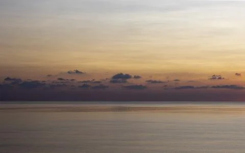 Sunset over the sea, a row of clouds on the horizon and the sun has set. Stock Photos