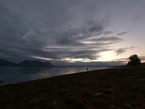 Sunset over sea shore with clouds and mountains on the horizon timelapse Stock Footage 205572069