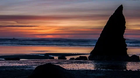 Sunset over sea stack on rocky beach, wide shot Stock Footage 342396148