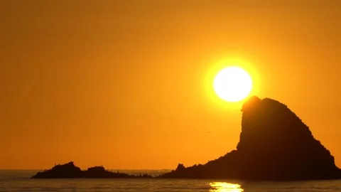 Sunset over the sea. Sun setting behind the cliff. 20x timelapse Stock Footage 82487459