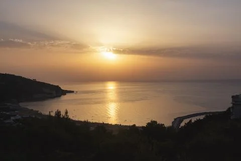 A sunset over the sea with the sun setting behind it Stock Photos