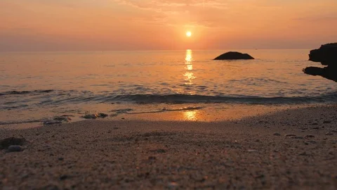 Sunset over the sea. Sunlight blinks on water surface. Gentle surf rolls on Stock Footage 102457890