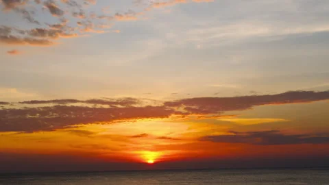 Sunset over sea with vibrant orange sky at calm ocean horizon Stock Footage 336462108