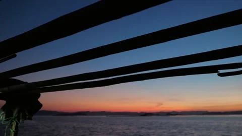 Sunset over the sea viewed from a boat with a wooden structure 스톡 동영상 312303085