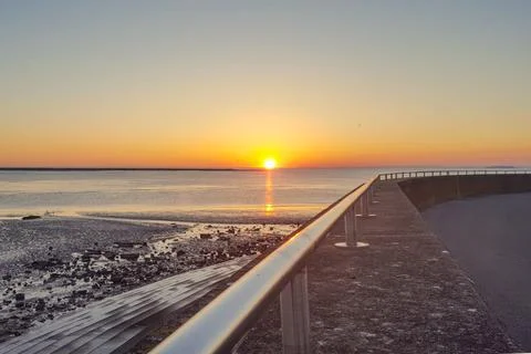Sunset over the sea wall railing at Burnham on Sea Somerset United Kingdom Фото