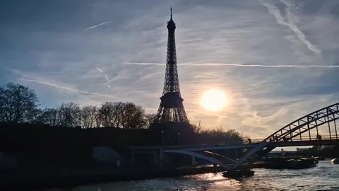 A sunset over the Seine river in Paris, featuring the Eiffel Tower silhouette wi Stock Footage 325048209