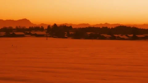 Sunset over a small country town with mountain skyline in snowy landscape Video stock 47223245