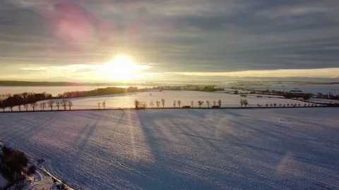 Sunset over the snowy fields, road and ice lake Stock Footage 151688309