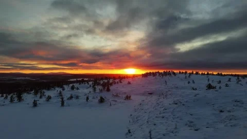 Sunset over snowy forest and mountain top in winter lapland, aerial drone video Stock Footage 301342920