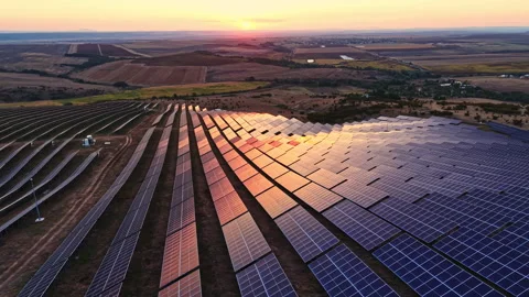 Sunset over solar panel array in rural area with fields and hills in the Видео 344799331