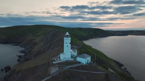 Sunset over Start Point Lighthouse, Trinity House and South West Coast Path, UK Stock Footage 246599912