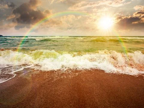 Sunset over storm on the sandy beach Stock Photos