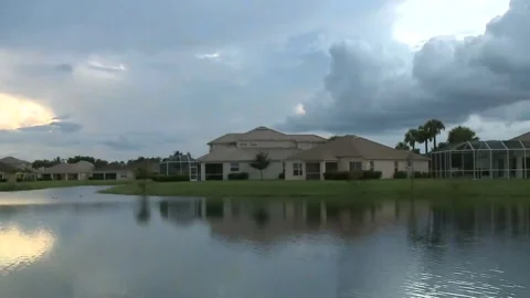 Sunset Over Suburban Lake with Clouds and House Reflections Stock Footage 327293260