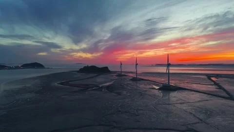 Sunset over Tando Sea Road with wind turbines and Nue Island silhouette in Видео 334697522