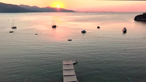 Sunset Over a Tranquil Beach with Boats Stock Footage 282931094