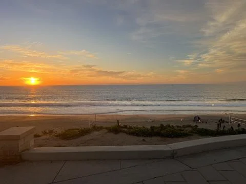 Sunset Over the Tranquil Beach With Waves Gently Lapping the Shore Stock Photos