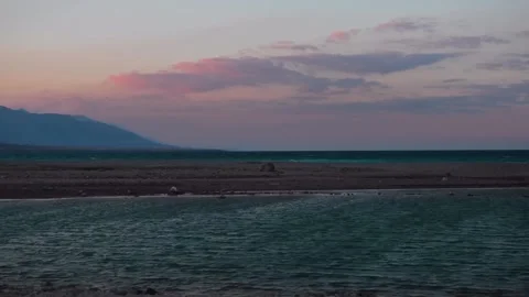 Sunset over the tranquil coast of Oman with mountains in the distance Video stock 318824354