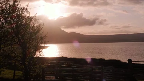 Sunset over tranquil lake with mountains in the background Stock Footage 310239681
