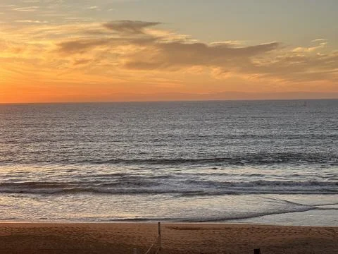 Sunset Over the Tranquil Ocean at the Beach During Golden Hour Stock Photos
