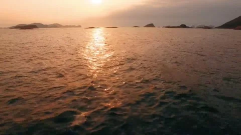 Sunset over tranquil ocean with distant islands, golden light reflecting on.. Stock Footage 302308421