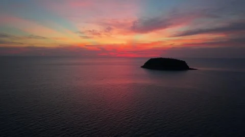 Sunset over tranquil ocean with distant island silhouette and colorful sky Vídeos de archivo 342312720