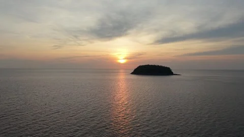 Sunset over tranquil ocean with island silhouette and colorful sky reflections Video stock 340406820