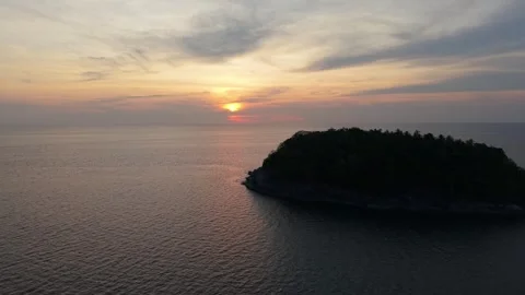 Sunset over tranquil ocean with island silhouette and colorful sky reflections Video stock 342331445