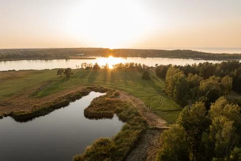 Sunset Over Tranquil River with Lush Greenery and Trees Foto stock