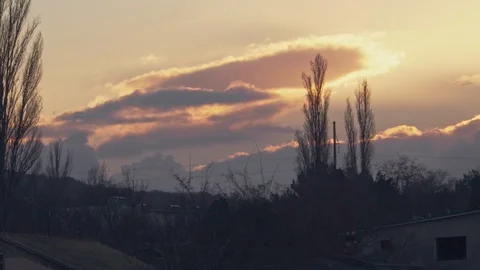 Sunset over trees without leaves with fast passing clouds Stock Footage 104379557