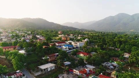 Sunset over a tropical town, orange sunbeams illuminate the houses. Stock Footage 247233286