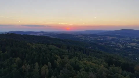 Sunset over valley panorama from mountain ridge featuring forests, scattered Stock Footage 345170932