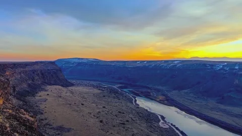 Sunset over vast canyon with river flowing through remote landscape aerial view Stock Footage 345483977