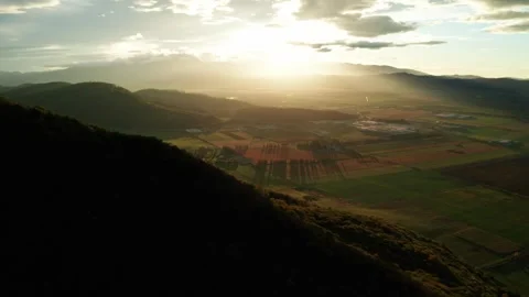 Sunset over vast, patchwork farmlands and rolling hills with a serene, Stock Footage 280221035