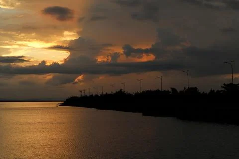 Sunset Over Water with Dark Cloudy Sky Stock Photos