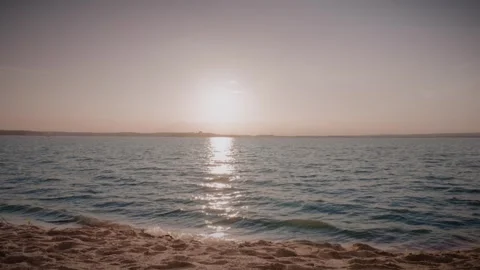 Sunset over water with distant coastline and clouds Stock Footage 292868871