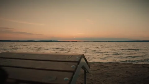 Sunset over water with distant coastline and clouds Video stock 292868937