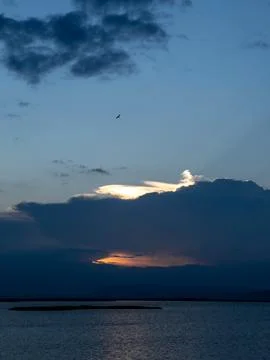 Sunset Over Water With Dramatic Clouds Stock Photos