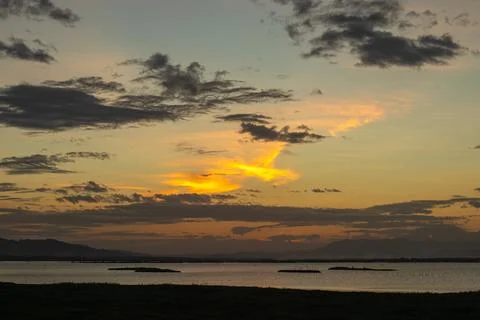 Sunset Over Water With Dramatic Clouds Stock Photos