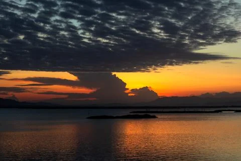 Sunset Over Water With Dramatic Clouds 库存照片