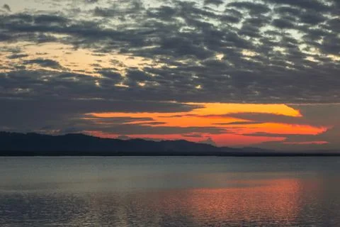 Sunset Over Water With Dramatic Clouds Stock Photos
