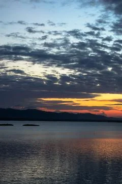 Sunset Over Water with Dramatic Clouds Stock Photos