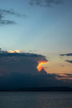 Sunset Over Water With Dramatic Clouds Stock Photos