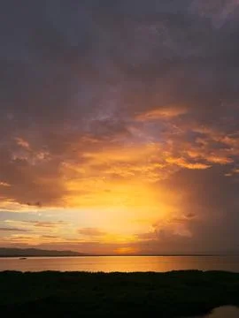 Sunset Over Water with Dramatic Clouds Stock Photos