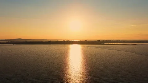 Sunset over the water showing reflection and city skyline in the background Stock Footage 336560059