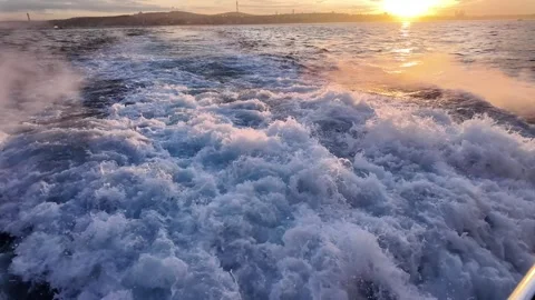 Sunset over water with waves splashing near shore Stock Footage 333089277