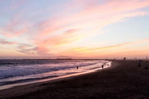 Sunset over waves hitting the beach on the west coast Stock Photos