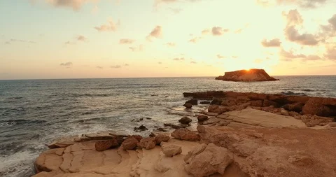 Sunset over the wavy sea. shooting from the air. Rocky coast. island on the hori Stock Footage 97301014