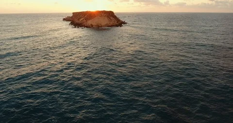 Sunset over the wavy sea. shooting from the air. Rocky coast. island on the hori Stock Footage 97301057
