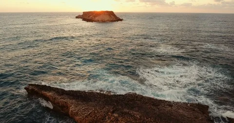 Sunset over the wavy sea. shooting from the air. Rocky coast. island on the hori Stock Footage 97301159